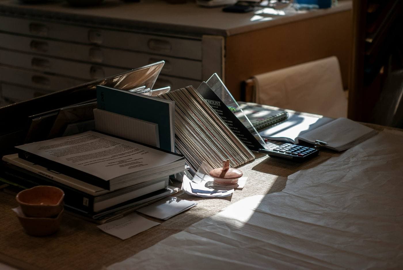 Warm desk with calculator, ledgers, and papers