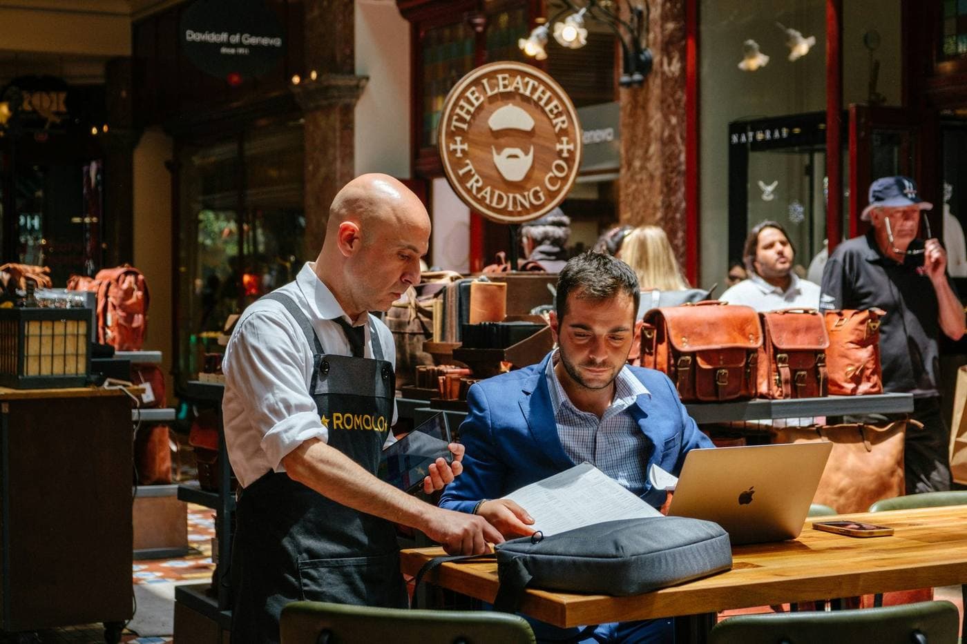 Store manager and area director reviewing operations on a laptop in-store